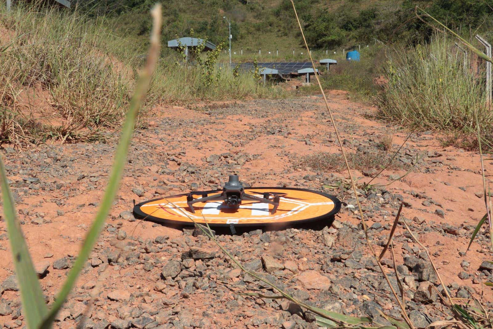 Drone surveying equipment on a dirt path in a rural area.