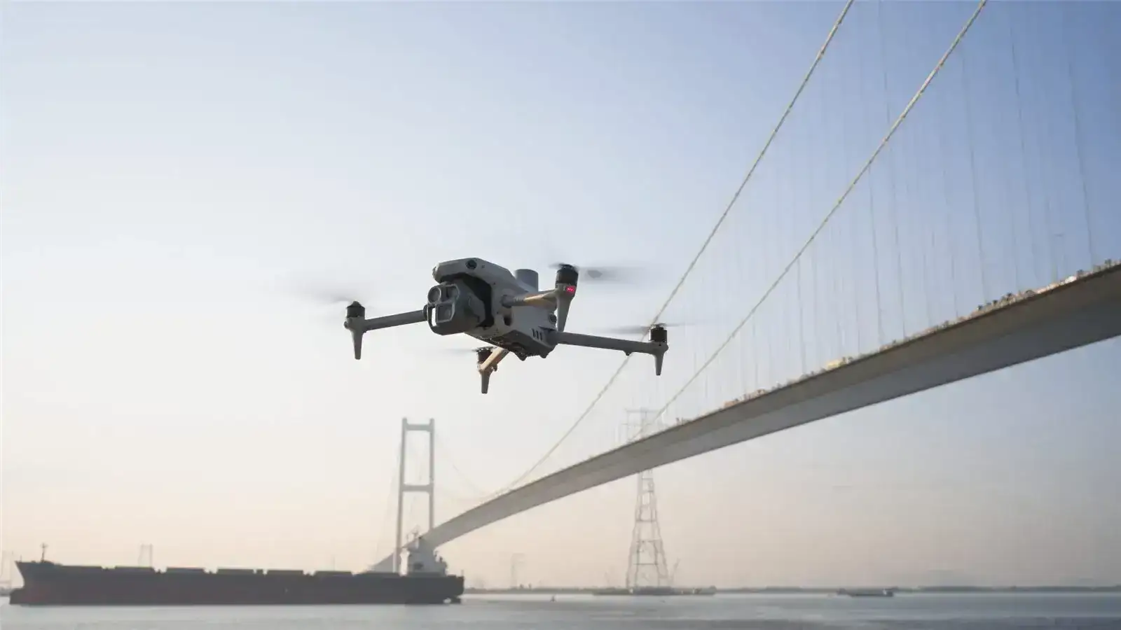 DJI Matrice 4E RTK drone flying beside a suspension bridge
